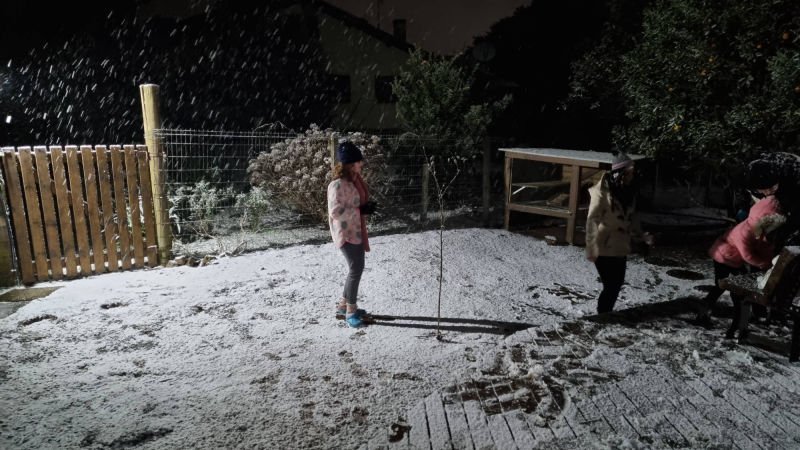 Neve caindo à noite sobre o terreno do Chalé Rural